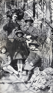 Bill Hutchinson standing with a man and three children in a glasshouse, Shanghai, Hongkou, Shanghai