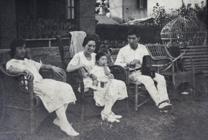 Maggie, Sarah, Bea, and Tom Hutchinson (with film holder and camera), in the garden, 35 Tongshan Road, Hongkou, Shanghai