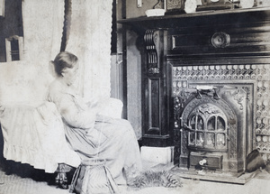 Elizabeth Hutchinson sitting and knitting in front of an art deco fireplace, 35 Tongshan Road, Hongkou, Shanghai