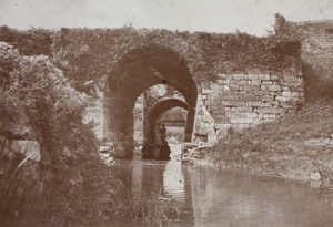 River barge passing passing through two arches of an old watergate