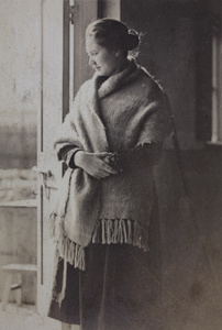 Sarah Hutchinson wearing a blanket shawl standing by a an open doorway, 35 Tongshan Road, Hongkou, Shanghai