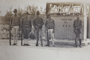 Chinese policeman and four American Marines standing in front of Police Box W.1., Shanghai