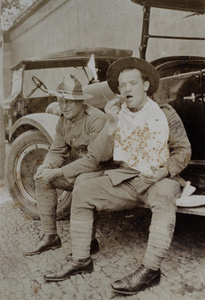 Two members of American Company Shanghai Volunteer Corps, billeted at the Mixed Court building, Zhejiang Road, sitting on the footboard of a jeep, Shanghai, October 1924