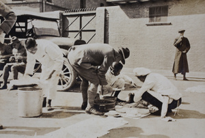 Chinese cooks serving up food to American Company Shanghai Volunteer Corps members billeted at the Mixed Court building, Zhejiang Road, Shanghai, October 1924
