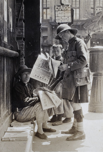Scottish Company SVC member with a newspaper vendor and other customers, Shanghai, 1925