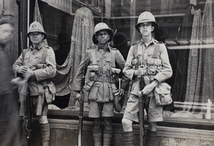 British B Company Shanghai Volunteer Corps with rifles, on guard in front of a shop window, Shanghai, 1925