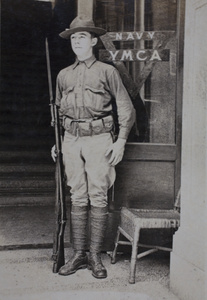 Mr Upson, American Company Shanghai Volunteer Corps member, on duty at the entrance to the Navy YMCA, Shanghai, 1925