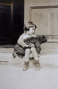 Bea Hutchinson sitting on the verandah steps and holding a cat, 35 Tongshan Road, Hongkou, Shanghai 