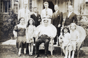 William Hutchinson and his granddaugher, Lorraine Henderson, with a group of unidenitfied people, in the front garden, 31 Lucerne Road, Shanghai