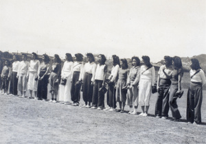 Gladys Hutchinson in a line up of softball players, Kowloon, Hong Kong