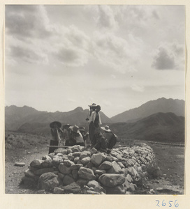 Villagers near a low stone structure in the Lost Tribe country