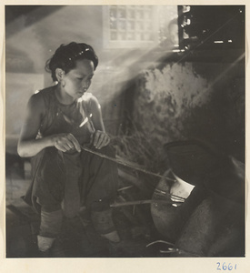 House interior showing woman with bound feet tending a stove in the Lost Tribe country