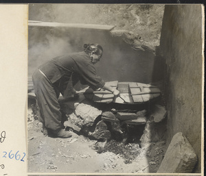 Woman cooking in the courtyard of a house in the Lost Tribe country