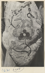 Child wearing an apron with appliquéd flowers in the Lost Tribe country