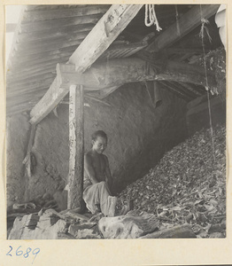 Man splitting wood to make incense at factory west of Ts'a-ho Village [sic] in the Lost Tribe country
