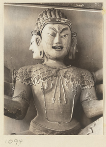 Detail showing head and torso of a statue of a multi-headed, multi-armed Bodhisattva