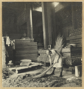 Interior view of a temple at Da Fo si showing material for restoring the temple and a man sweeping