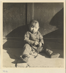 Child holding a piece of chain in Baoding