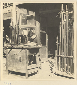 Man at work in front of a shop displaying poles in Baoding