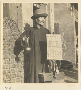 Man holding bell and sign offering treatment for leg and foot ailments in Baoding