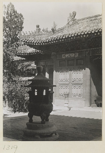 Building with roof ornaments and courtyard with incense burners on stone pedestals in the Forbidden City