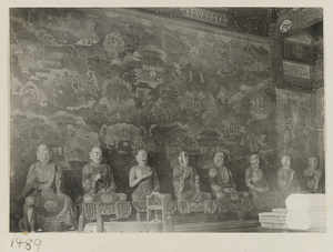 Interior view showing statues of eight Luohans in front of a mural at Qian men temple or Guan di miao