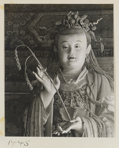 Detail of a statue showing head and hands of a shrine figure holding a sheaf of grain at Da Fo si