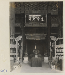 Interior view of Da cheng dian showing altar with Confucius' tablet, inscribed board, and musical instruments at Kong miao