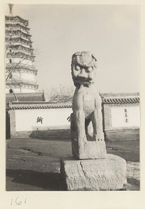 Statue of a lion in front of a storied wooden pagoda at Tian ning si