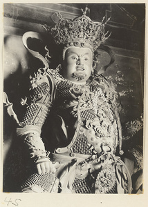 Detail of a celestial king holding an animal at Xi yu si