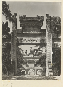 View through central arch of marble pai lou showing gate and Jin gang ta at Bi yun si