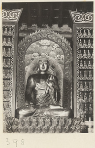 Temple interior showing niche with statue of Buddha and walls with Bodhisattva reliefs at Wan shou si