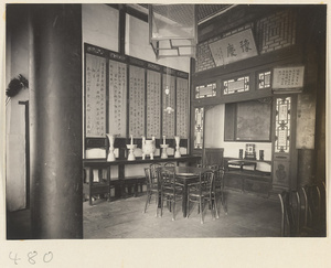 Interior of a temple building showing a room with tables, chairs, scrolls, and latticework at Fa yuan si