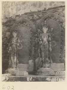 Temple interior showing statues of two Bodhisattvas and mural details