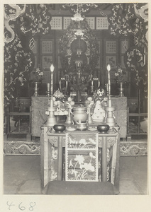 Temple interior showing altar with Buddha statue, ritual objects, offerings of food, and altar cloths at Fa yuan si