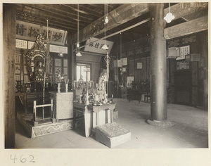 Temple interior showing altars with Buddha statues, ritual objects, scrolls, and a portrait at Fa yuan si