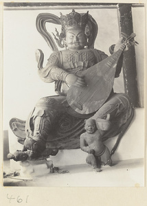 Statue of a celestial king playing a stringed instrument at Fa yuan si