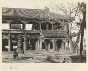 Detail of two-story temple building with open sides and incense burner at Huang si