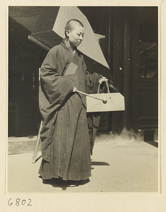 Buddhist nun striking a stone chime