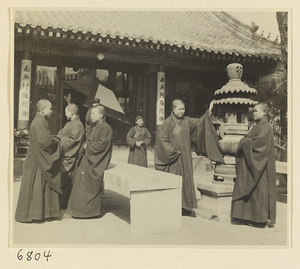 Buddhist nuns in courtyard of nunnery with incense burner