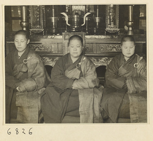 Buddhist nuns seated in front of altar