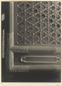 Exterior detail of a door at Qi nian dian showing latticework and metal decoration