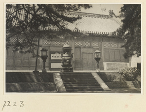 Facade detail of a single-story, single-eaved temple building at Jie tai si showing terrace with lanterns, inscription, and incense burner