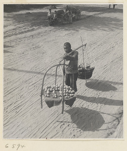 Produce vendor carrying his wares on a shoulder pole