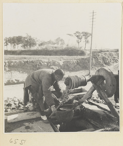 Man lifting a bucket of water out of a well