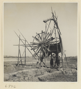 Men drawing water from a well to irrigate a field