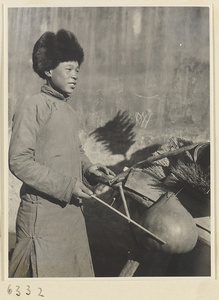 Household goods vendor striking a musical instrument called a pao
