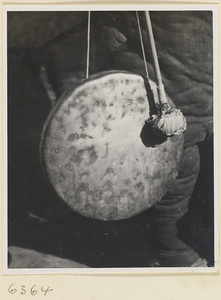 Toy vendor holding a gong called a tong luo
