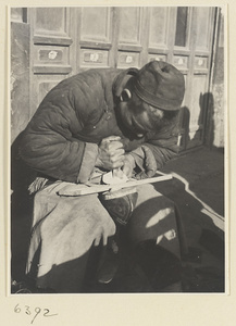 Itinerant shoe repairman repairing a shoe