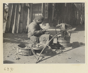 Itinerant shoe repairman with case and tools repairing a shoe